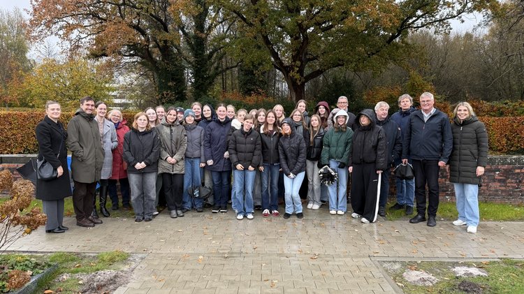 Eine große Gruppe von Jugendlichen und Erwachsenen lächeln in die Kamera