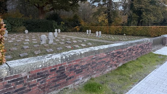 Die Kriegsgräberstätte mit einigen Kreuzen und vielen Kissensteinen